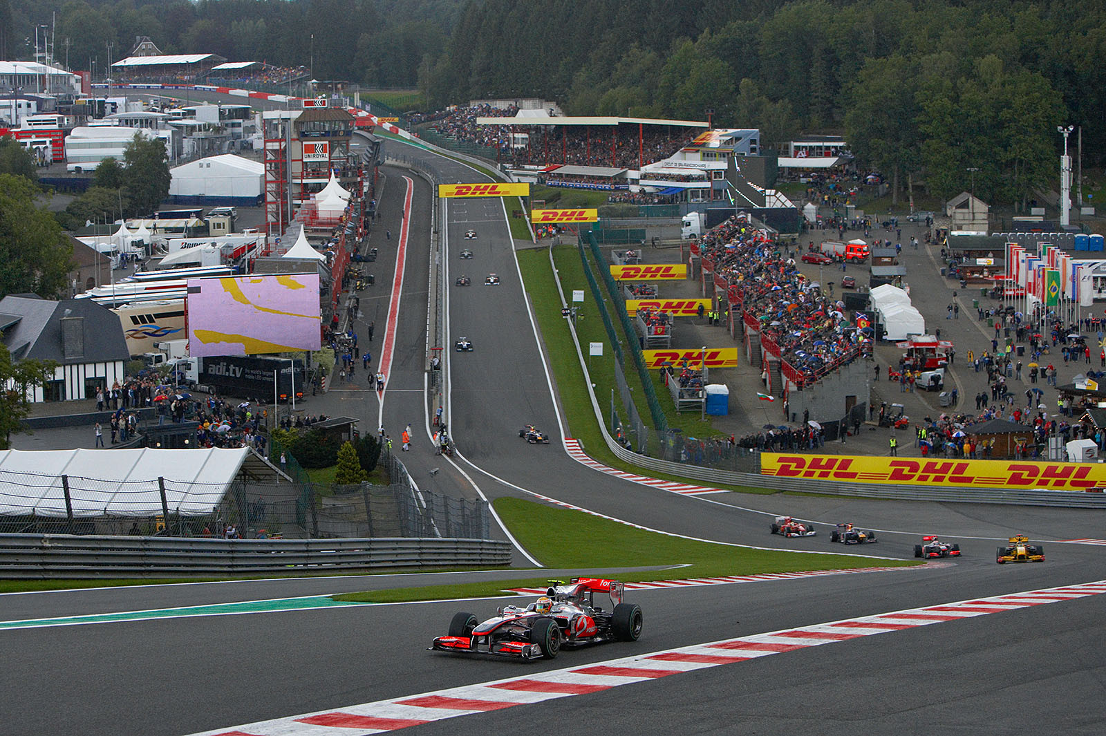 After two laps and under slowly starting light showers, Lewis Hamilton leads the field through Eau Rouge's chicane in front of Renault's Kubica and McLaren team mate Button