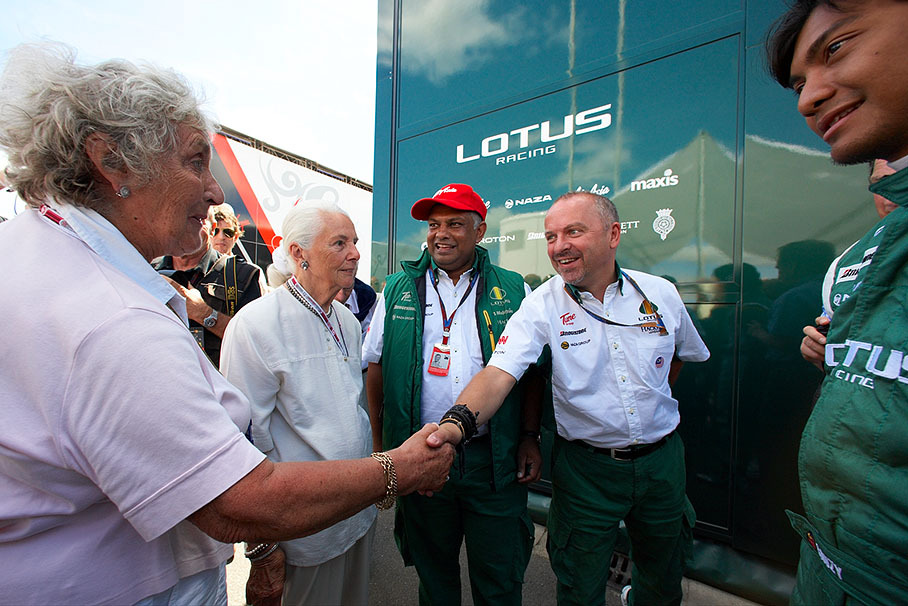 Top-class VIP guests inaugurate the new Lotus Racing motorhome: Bette Hill shakes hands with Lotus' technical director Mike Gascoyne in front of Hazel Chapman and Tony Fernandes