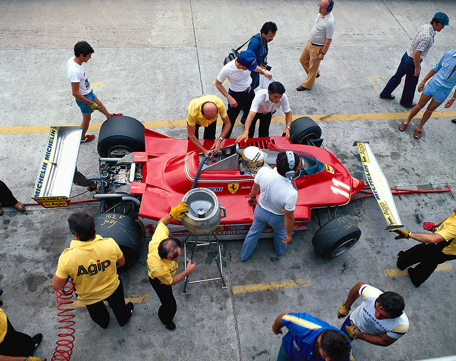 Championship leader Jody Scheckter in the Ferrari pits. Next to him with headphones on is Mauro Forghieri
