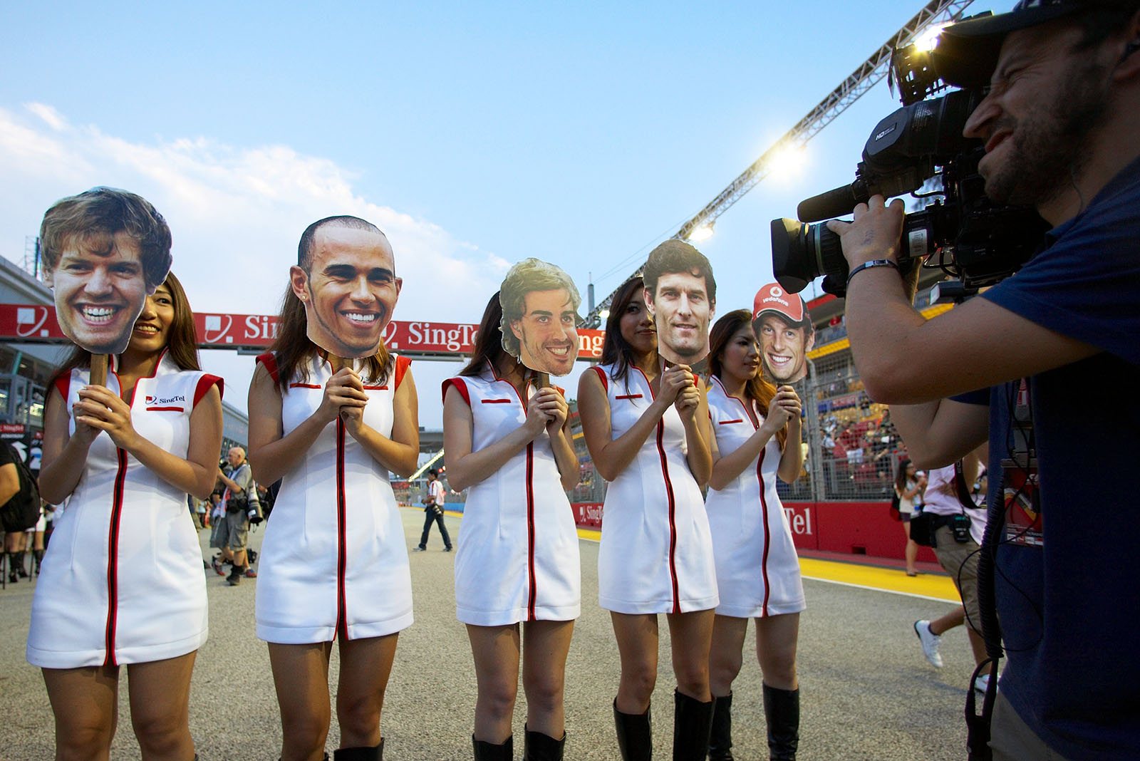 Grid girls hold the happy driver's portraits