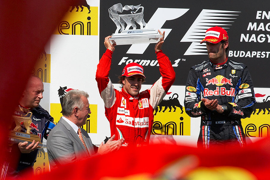 Fernando Alonso, Ferrari, raises his trophy for second place
