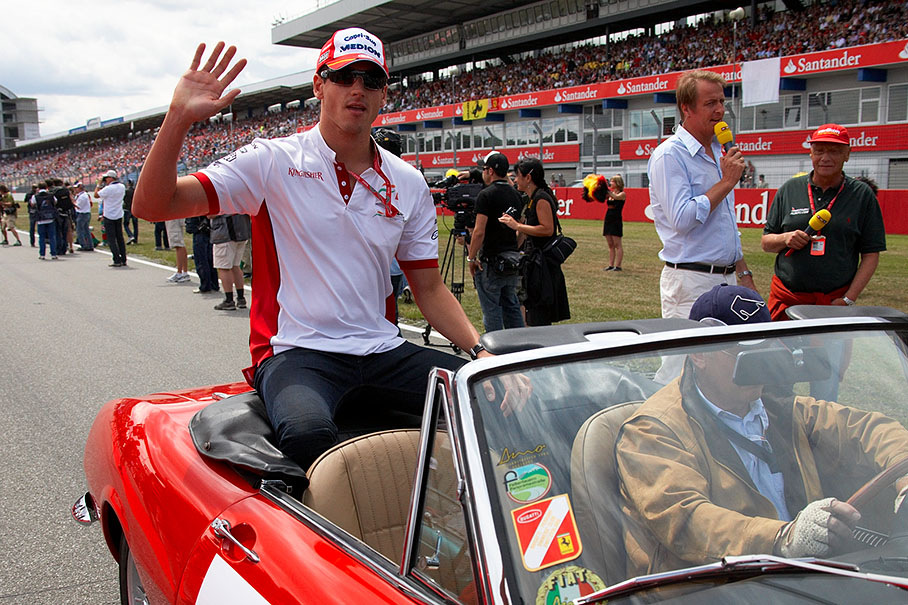 Adrian Sutil greets from a historic car at drivers parade