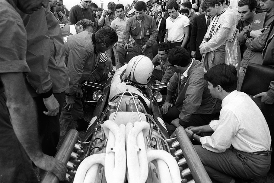 Chris Amon sits in a Ferrari 312 surrounded by tifosi