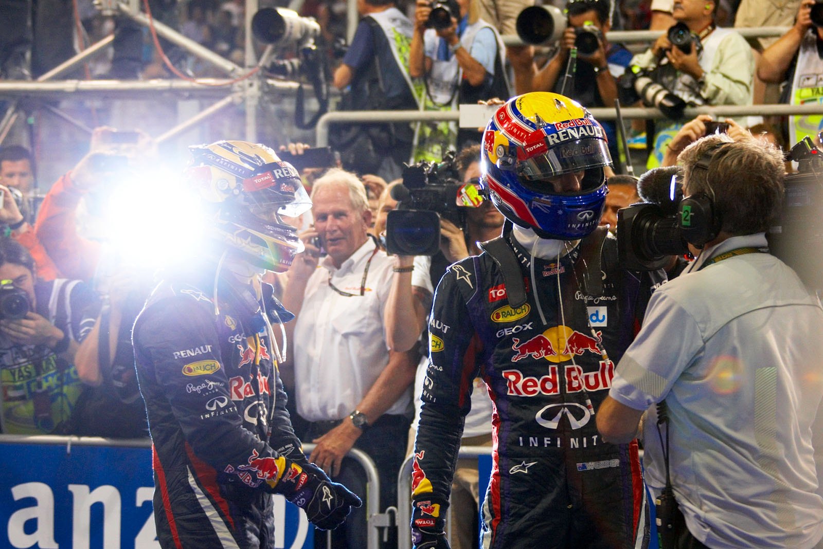 Helmut Marko takes a phone call while his winning Red Bull drivers Sebastian Vettel and Mark Webber are on their way to podium ceremony, Abu Dhabi Grand Prix, 2013