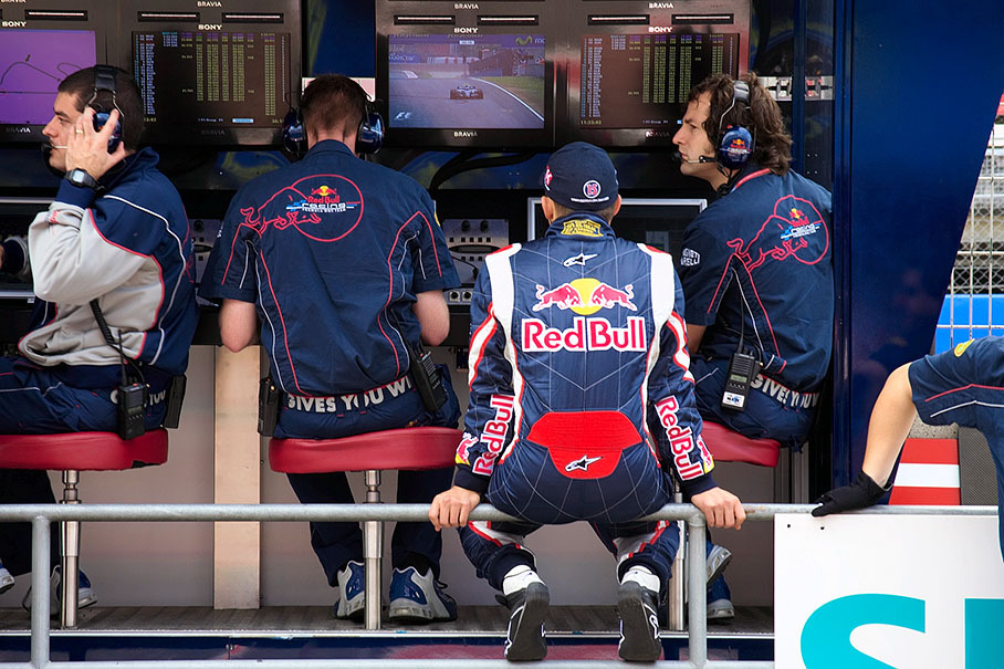 Christian Klien watching TV at the Red Bull pit wall