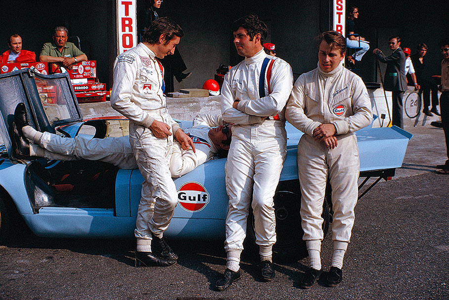 1000km Monza 1970: The Gulf-Porsche drivers Jo Siffert, Pedro Rodriquez (couching), Brian Redman and Leo Kinnunen relax at their business car in pits