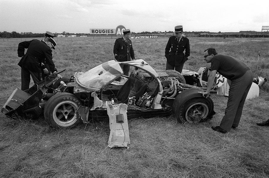 French policemen guard the remains of Richard Holquist's (USA) Ford GT40 #1029 which was not repaired in time before the race has started