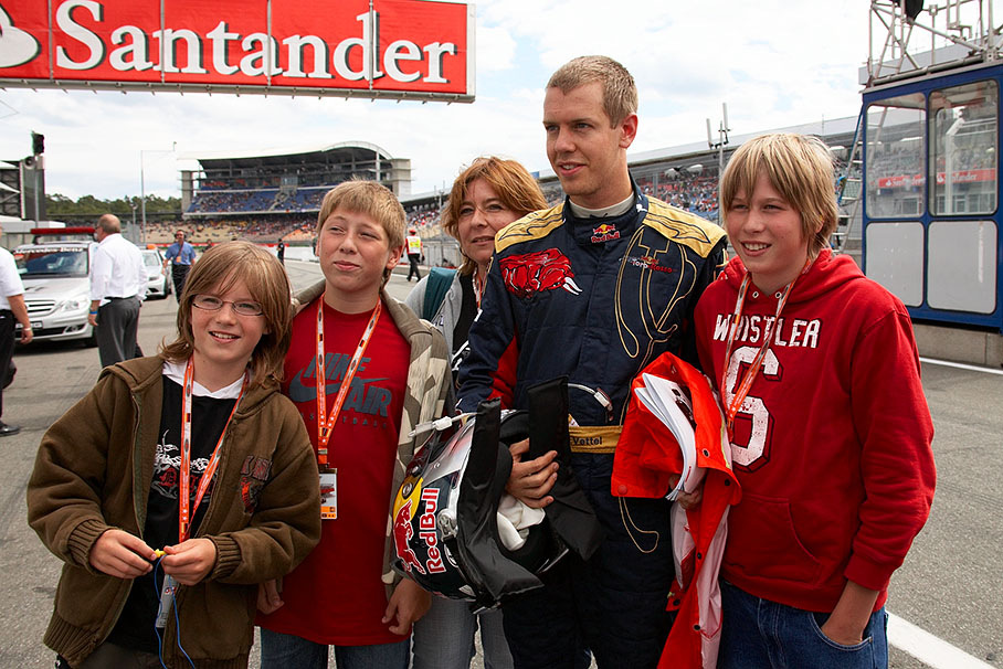 A souvenir photo of the whole family with Sebastian Vettel (except daddy who takes the picture)