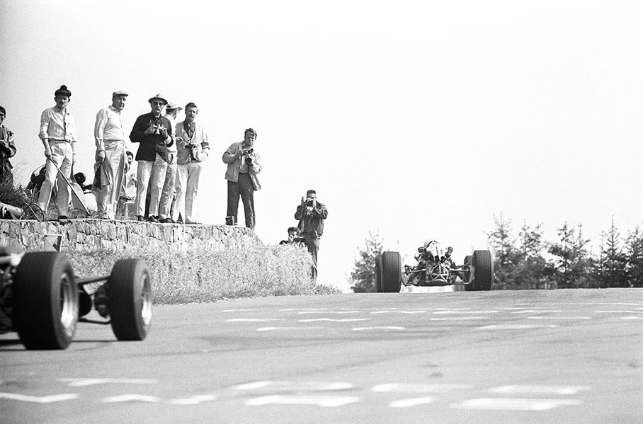 Eager photographers get close to the cars at the exit of Eau Rouge, Belgium GP 1967