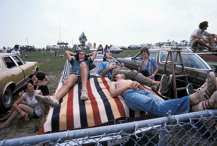Tired race fans take a nap on their car