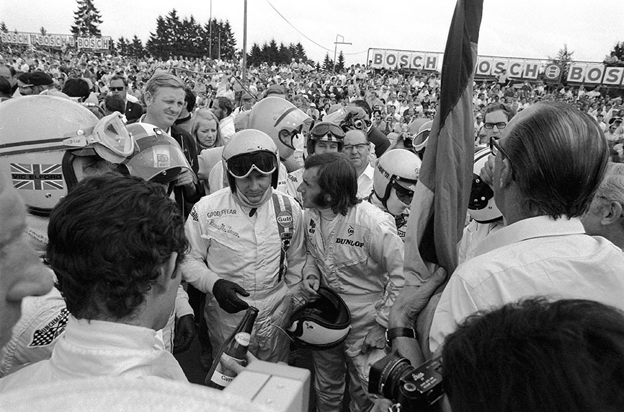 Bruce McLaren and Jackie Steward stand in front of the others during the drivers briefing prior to the German GP 1969