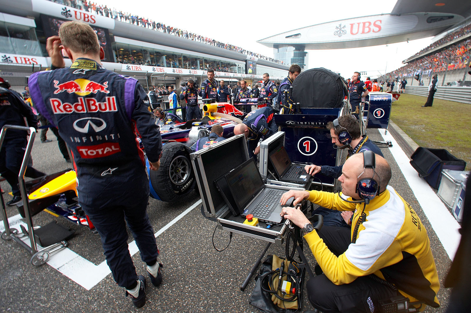 Vettel stands beside his Red Bull car on the grid, while Renault enineers work on a engine mapping program, Shanghai, Chineese Grand Prix, 2014