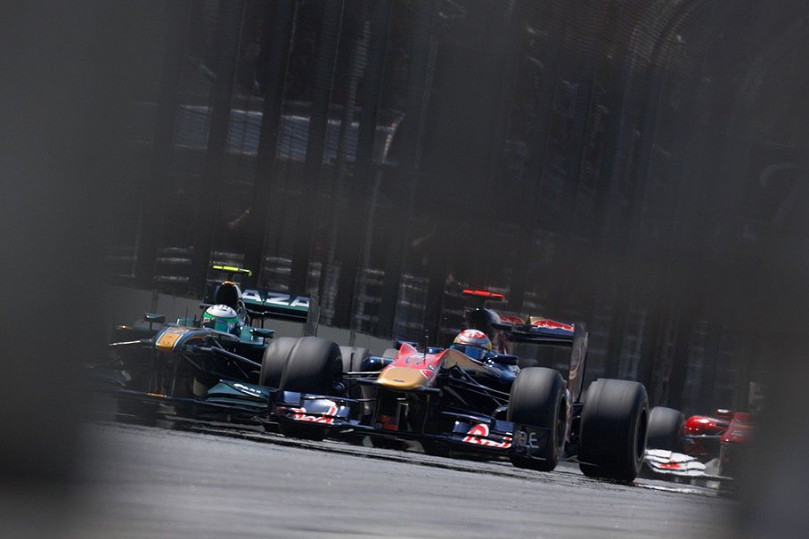 Sebastien Buemi, Toro Rosso, in front of Kovalainen and a Ferrari car
