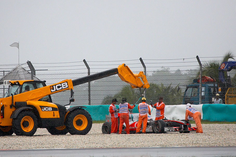 Jenson Button parks his McLaren Mercedes in the gravel during the wet Q1 session