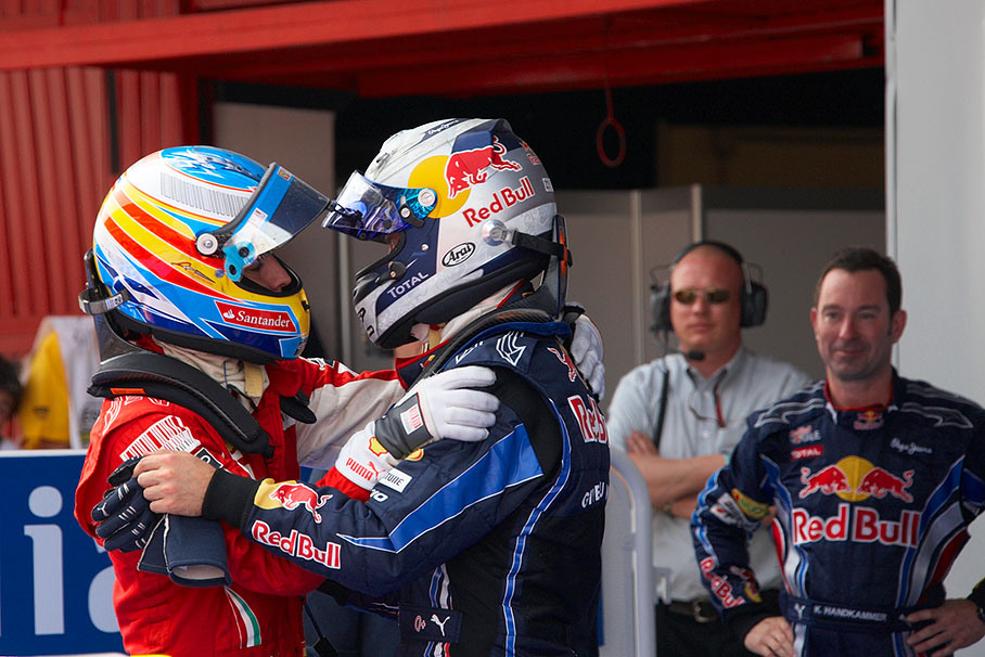 Alonso and Vettel hug each other in parc ferme after a hot ride