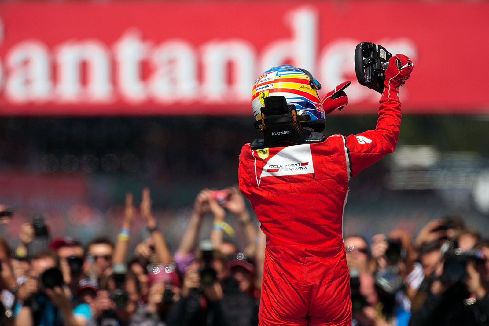 Race winner Fernando Alonso of Ferrari celebrates his victory in parc ferme, pointing at his steering wheel
