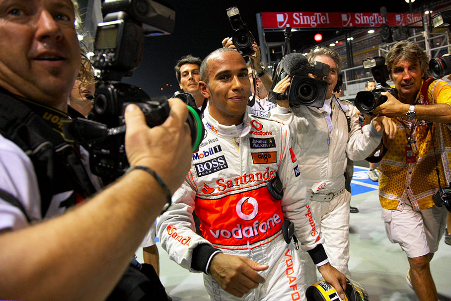 Happy polesetter Hamilton, entouraged by eager photographers, walks to parc ferme after Q3