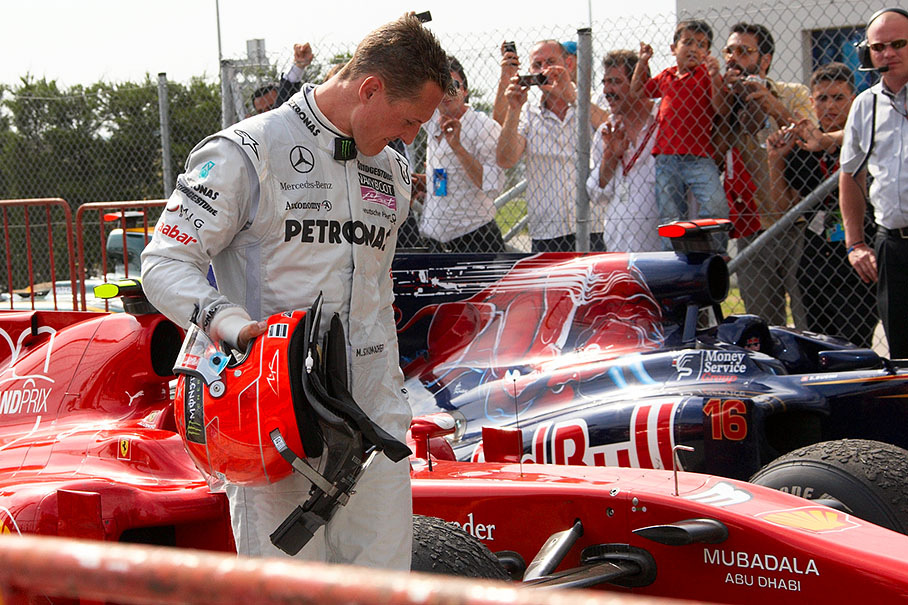 Michael Schumacher inspects the Ferrari's tyres in parc ferme after race