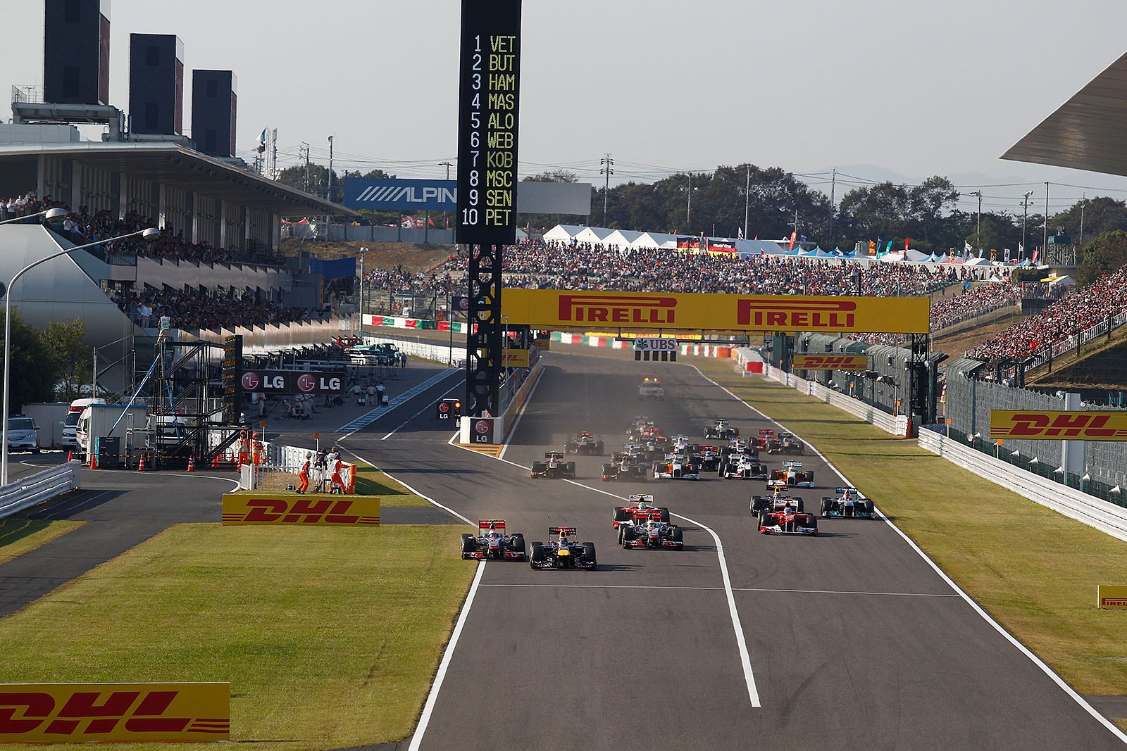 At the start, Jenson Button goes wide towards the lawn