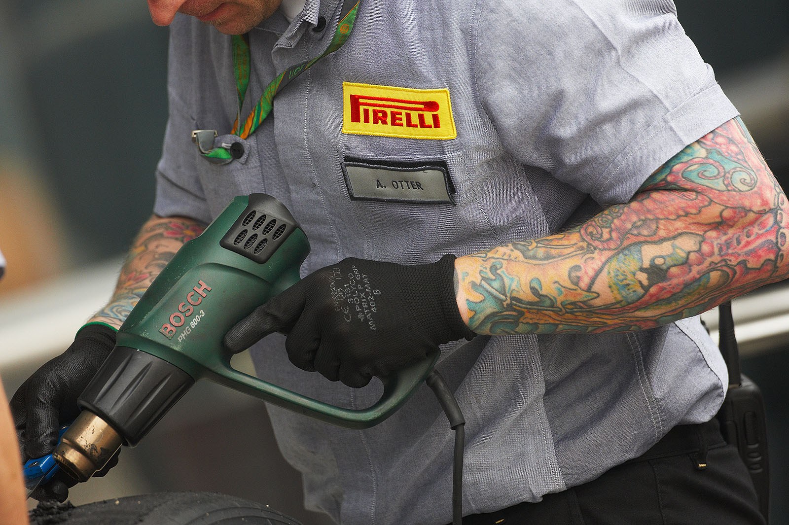 An inked Pirelli technician removes the dirty layer from the black gold