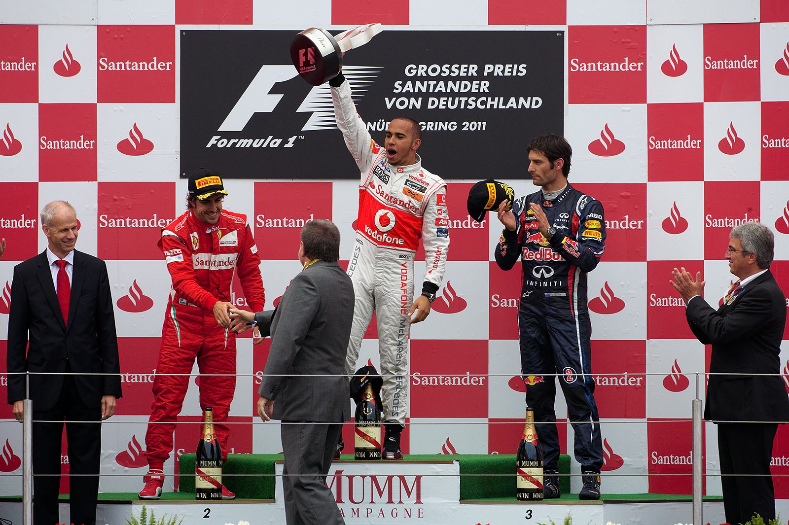 Race winner Lewis Hamilton of McLaren raises his trophy on the podium after the German GP