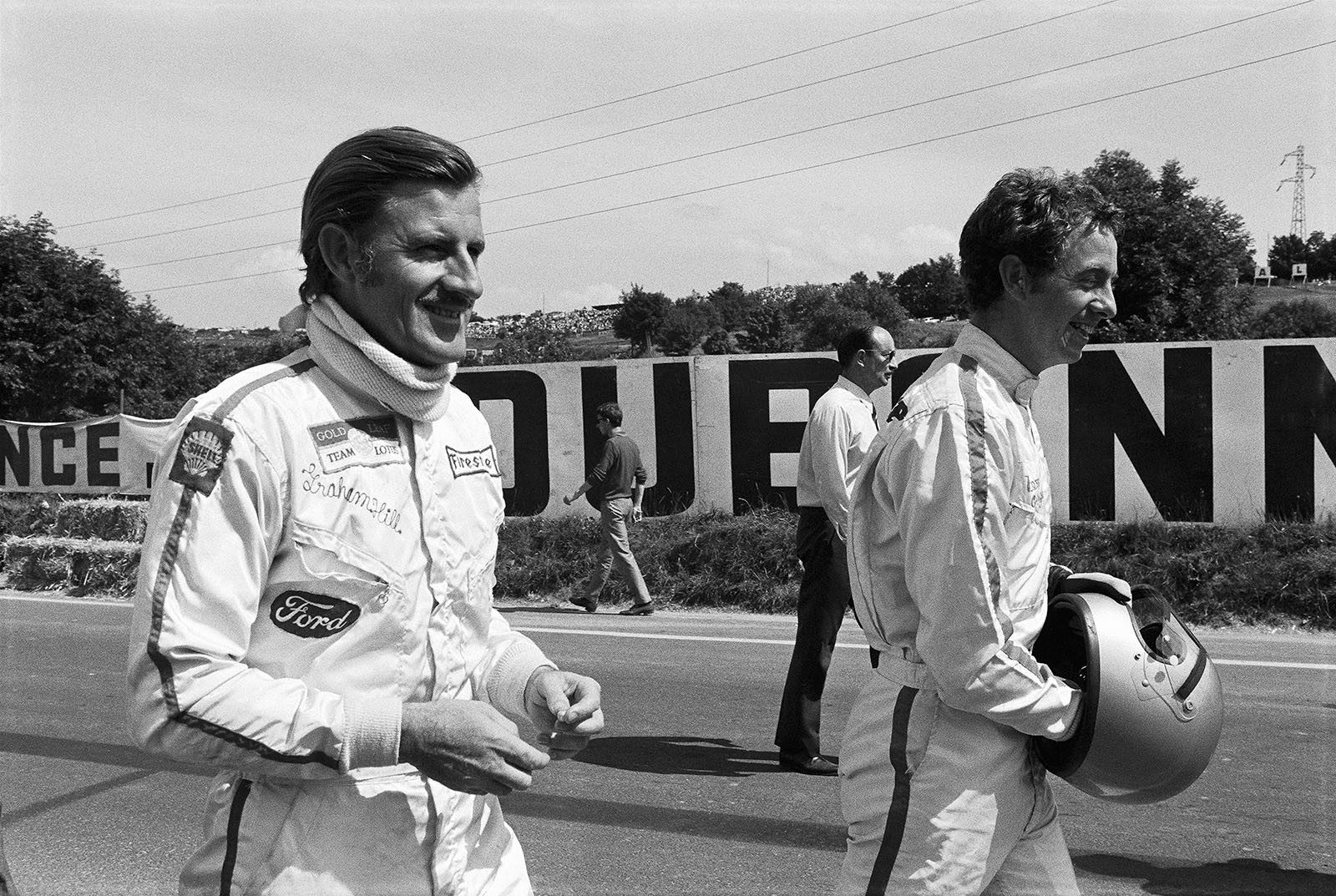 Before the start of the French GP at Clermont-Ferrand 1969: Graham Hill (Lotus driver) and Piers Courage walking through the grid.