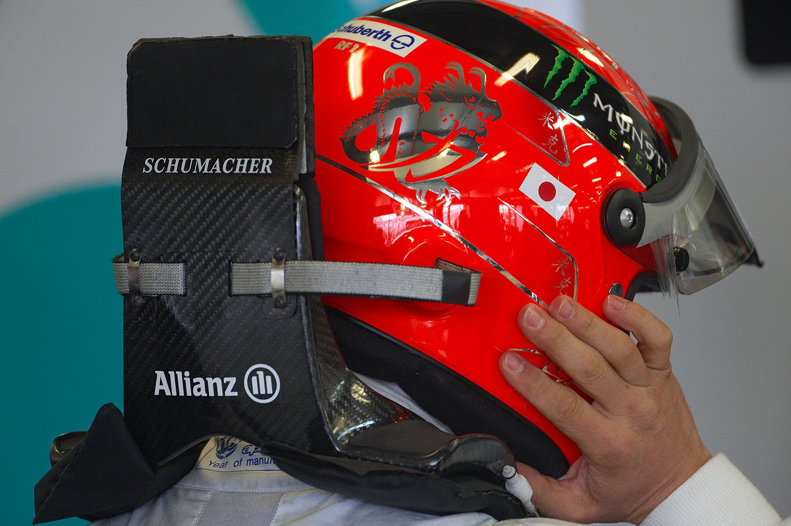 Michael Schumacher puts his helmet and HANS device on