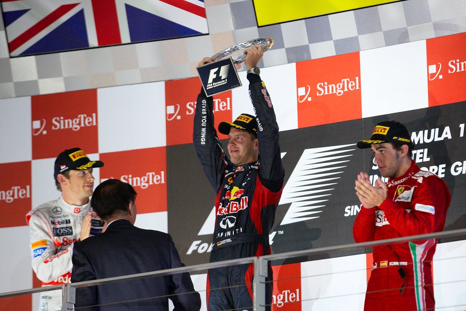 Race winner Sebastian Vettel of Red Bull Racing presents his trophy for the winning driver during the podium ceremony