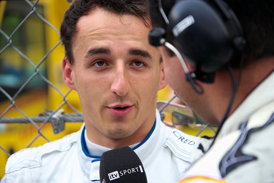 Robert Kubica being interviewed besides grid