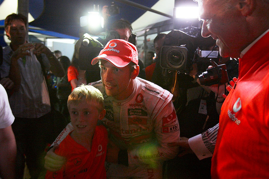 Jenson Button poses for a young McLaren fan's souvenir photo