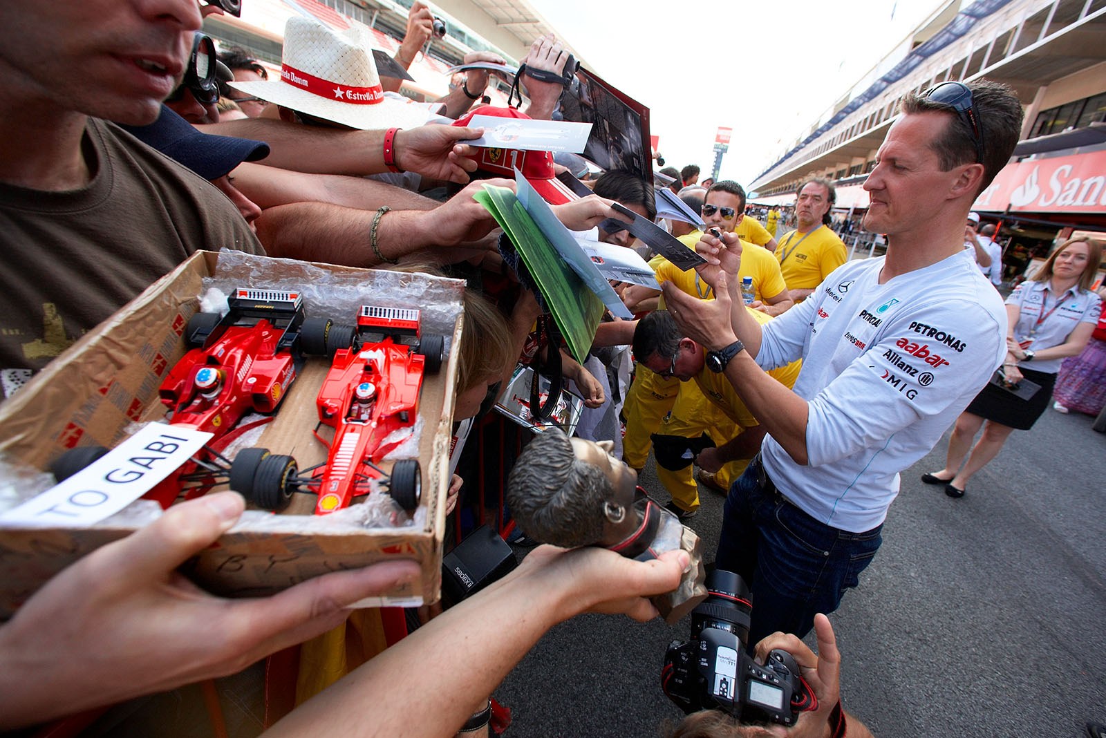 Michael Schumacher signs autographs for fans.