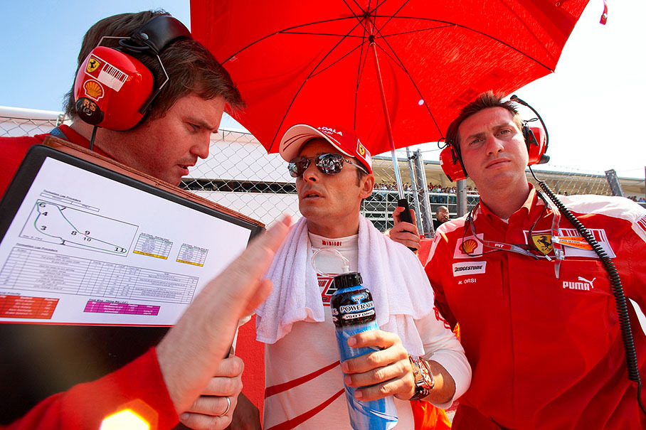 New Ferrari driver Giancarlo Fisichella on the grid before the race with race engineer Rob Smedley and physio Orsi
