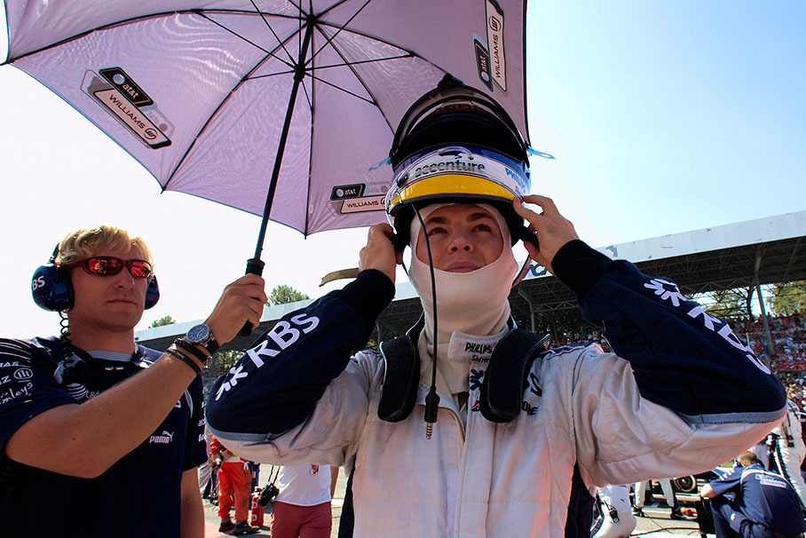Nico Rosberg puts his helmet on under the shelter of his physio Oliver