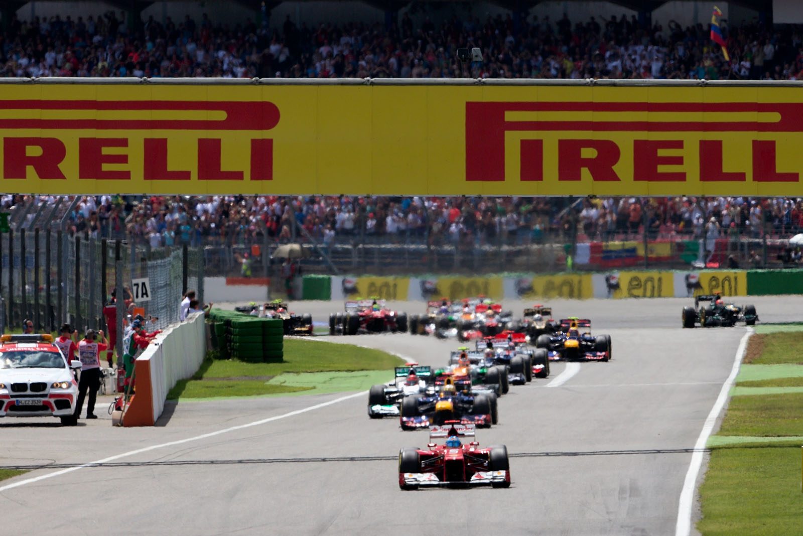 The start field with Ferrari's Alonso in the lead approaches turn two