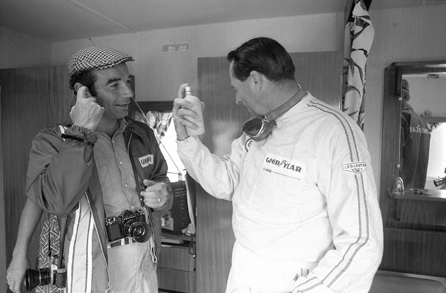 Bernard Cahier offering Jack Brabham a Goodyear clear water spray to refresh his face