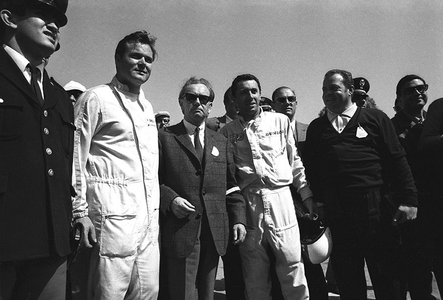 Dr. Ferry Porsche (middle, with tie) walks through the pitlane with his drivers Gerhard Mitter and Udo Sch¸tz (left)