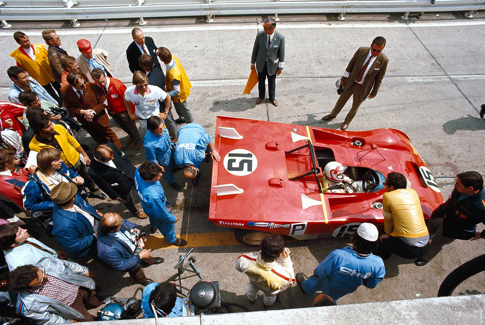Jacky Ickx (B) stands besides the Ferrari 312 PB #0878 and listens to what Clay Regazzoni (CH) talks to Mauro Forghieri whilst mechanics try to fix the overheating issue
