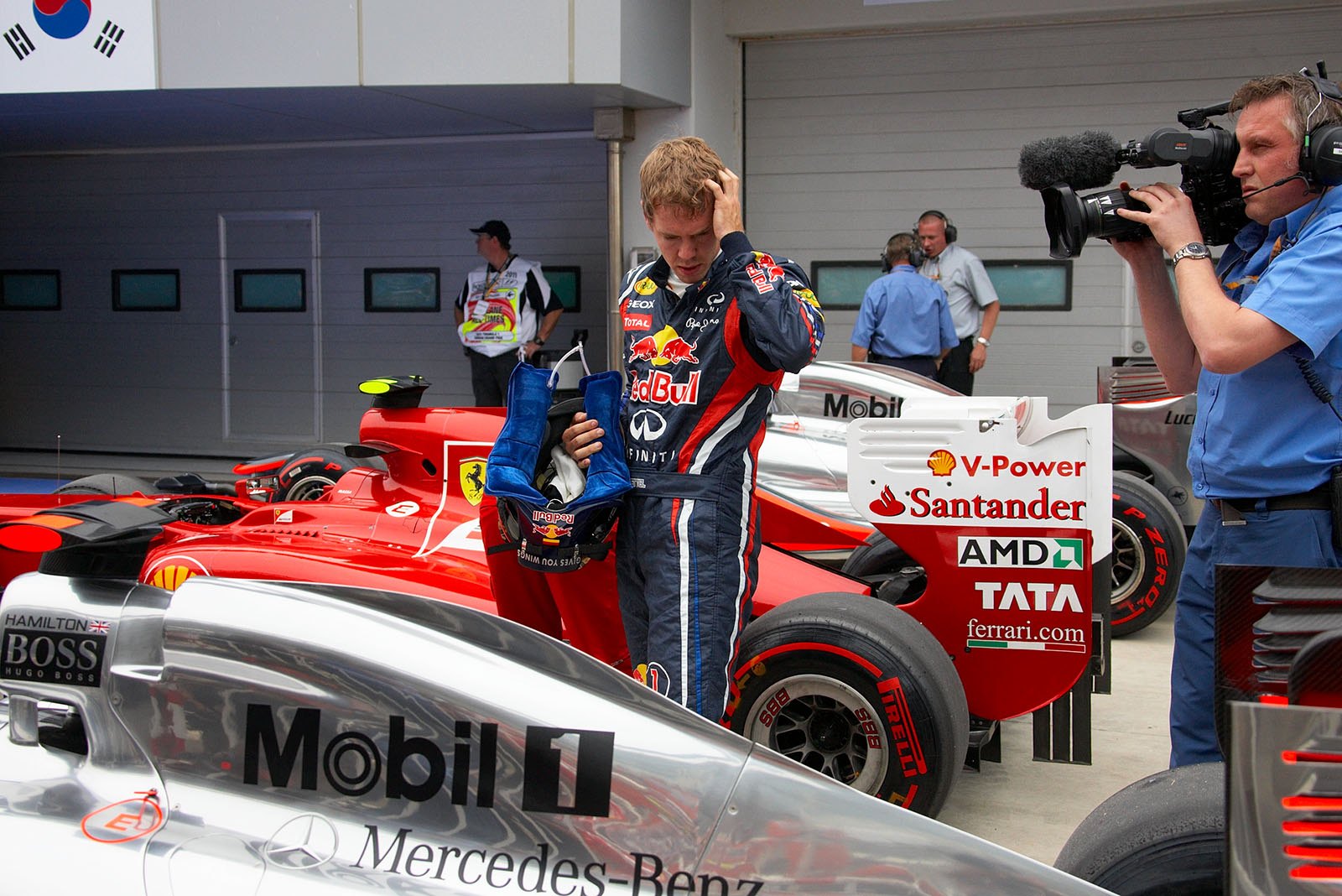 Second qualifier Sebastian Vettel studdies his competitor's car in parc ferme