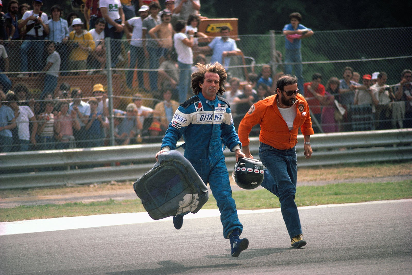 During Sunday morning warm-up Ligier driver  Jacques Laffite takes along his seat as he is about to swich to his t-car, Italian Grand Prix, Imola, 1980