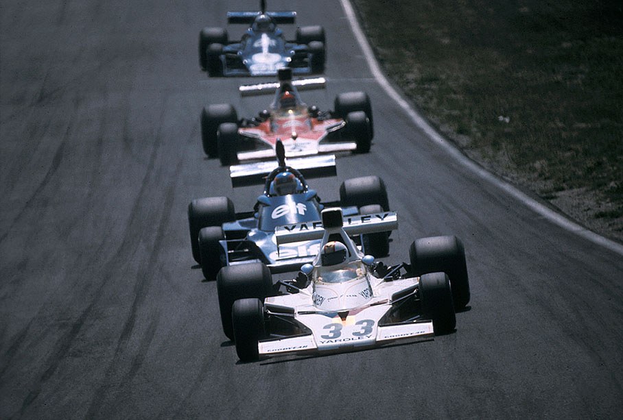 Mike Hailwood on McLaren-Cosworth M23 leads a queue of cars (Depailler, Fittipaldi and  Scheckter)