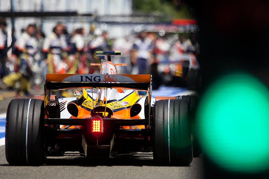 Passing the green pit lane entry lights, Nelson Piquet jr. aims at the Renault pit crew