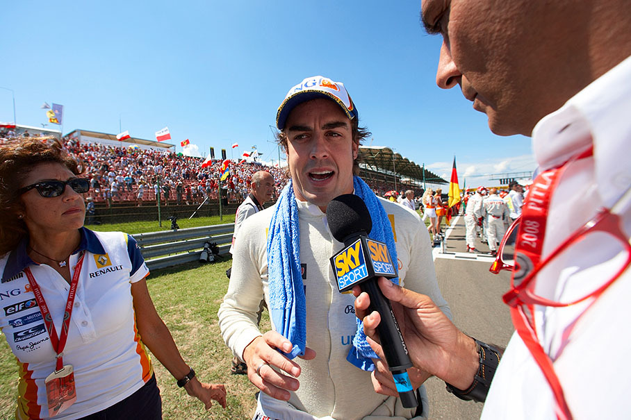 Fernando Alonso is being interviewed on the grid under the alert eyes (and ears) of Renault press officer Patrizia Spinelli