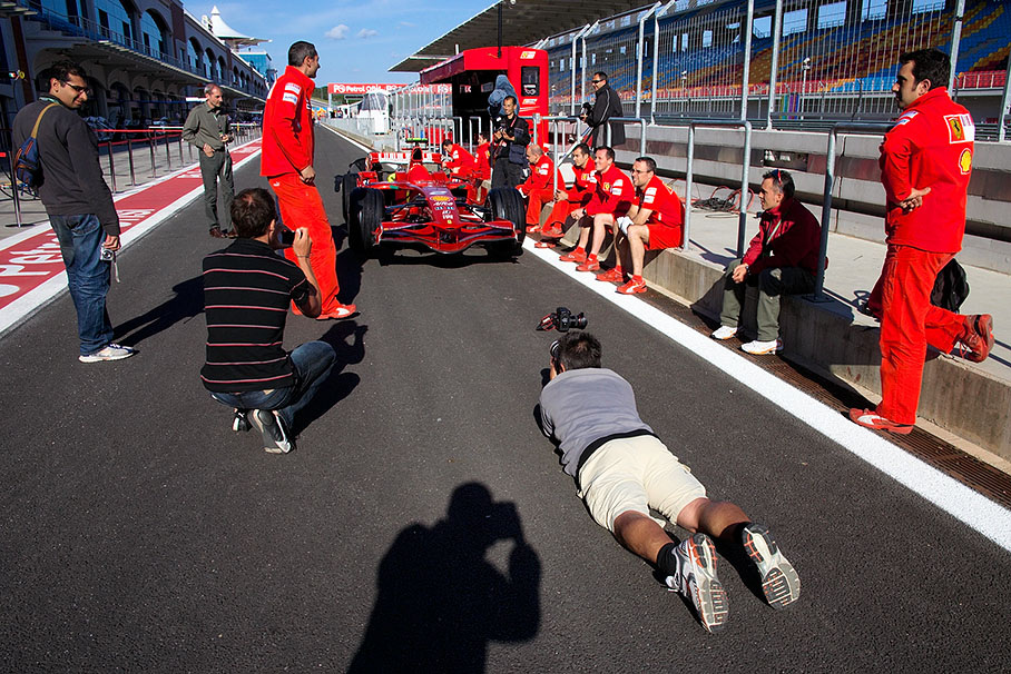 Rainer takes photos whilst Ferrari mechanics wait for FIA scrutineering in the evening