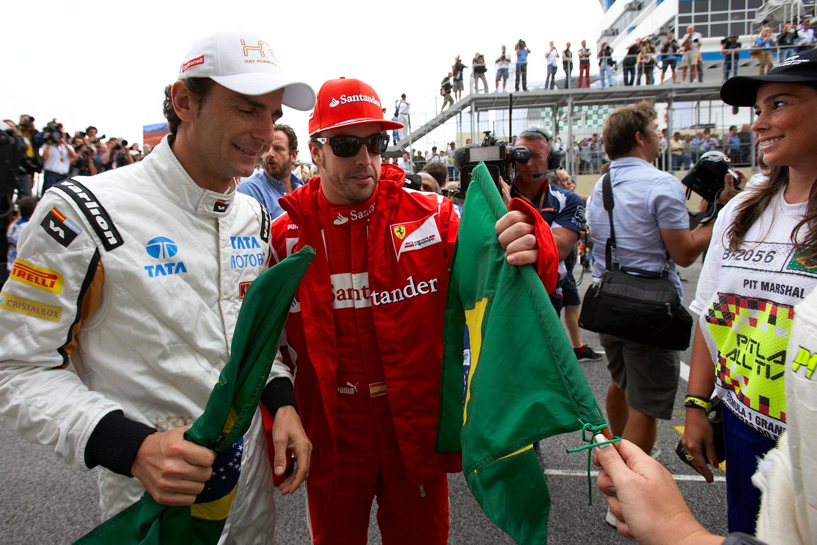Spaniards Pedro de la Rosa of HRT and Fernando Alonso of Ferrari take the Brazilian banner for  drivers presentation