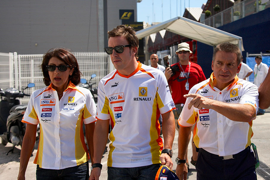 Local hero Fernando Alonso is being led to press conference centre