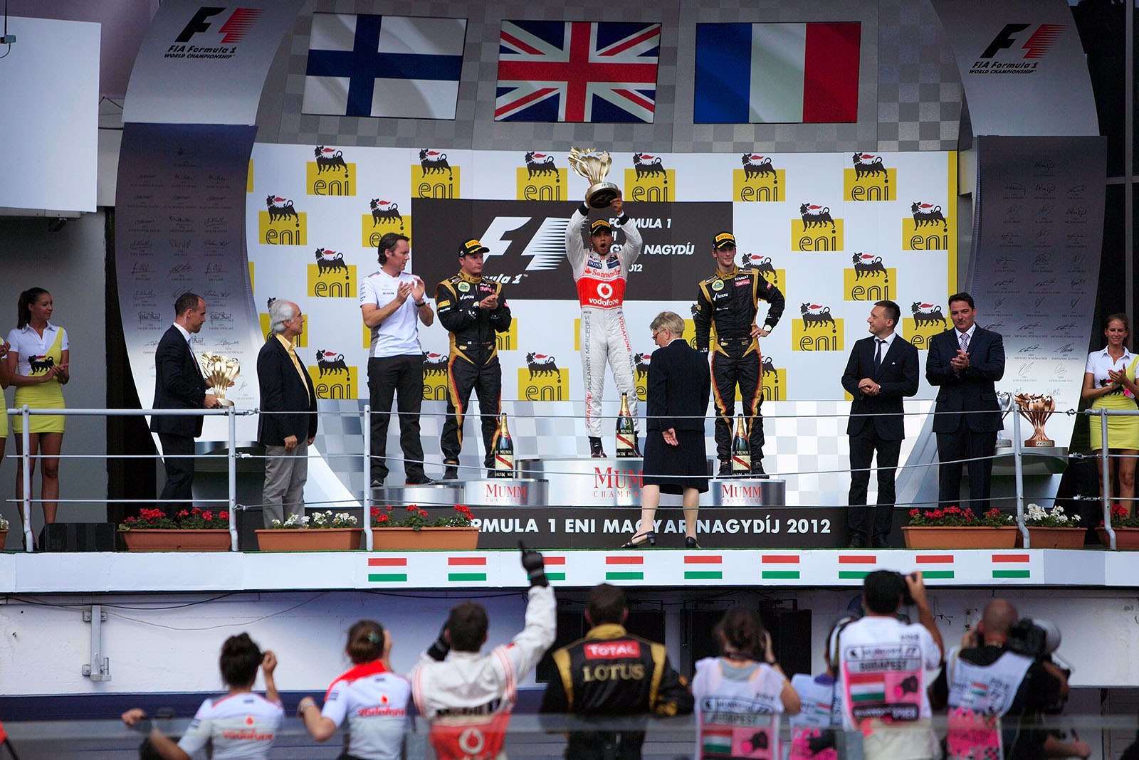 Race winner Lewis Hamilton of McLaren presents his trophy on the podium during the ceremony