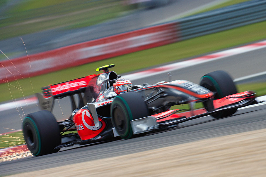 Sparks fly up from the rear of Heikki Kovalainen's McLaren Mercedes