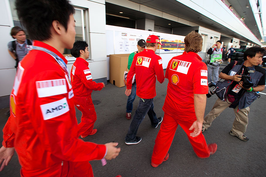 Kimi Raikkonen rushes through the paddock