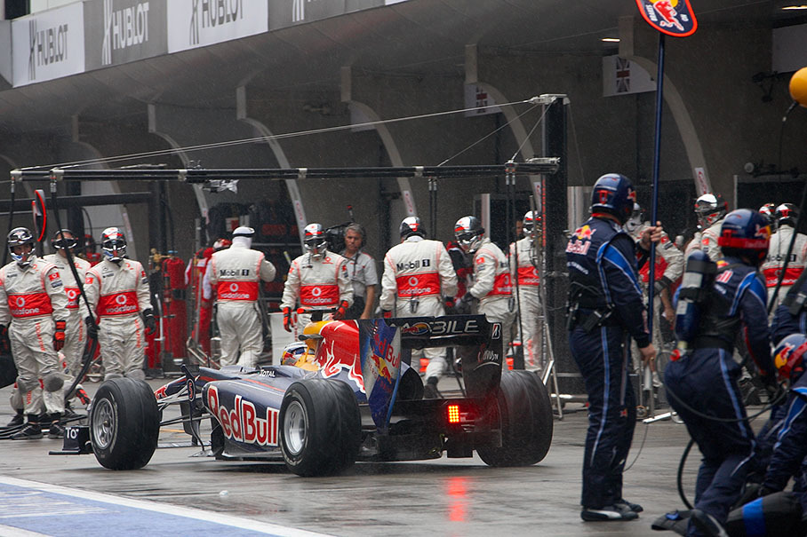 Sebastian Vettel lifts off a wet Red Bull Racing pits