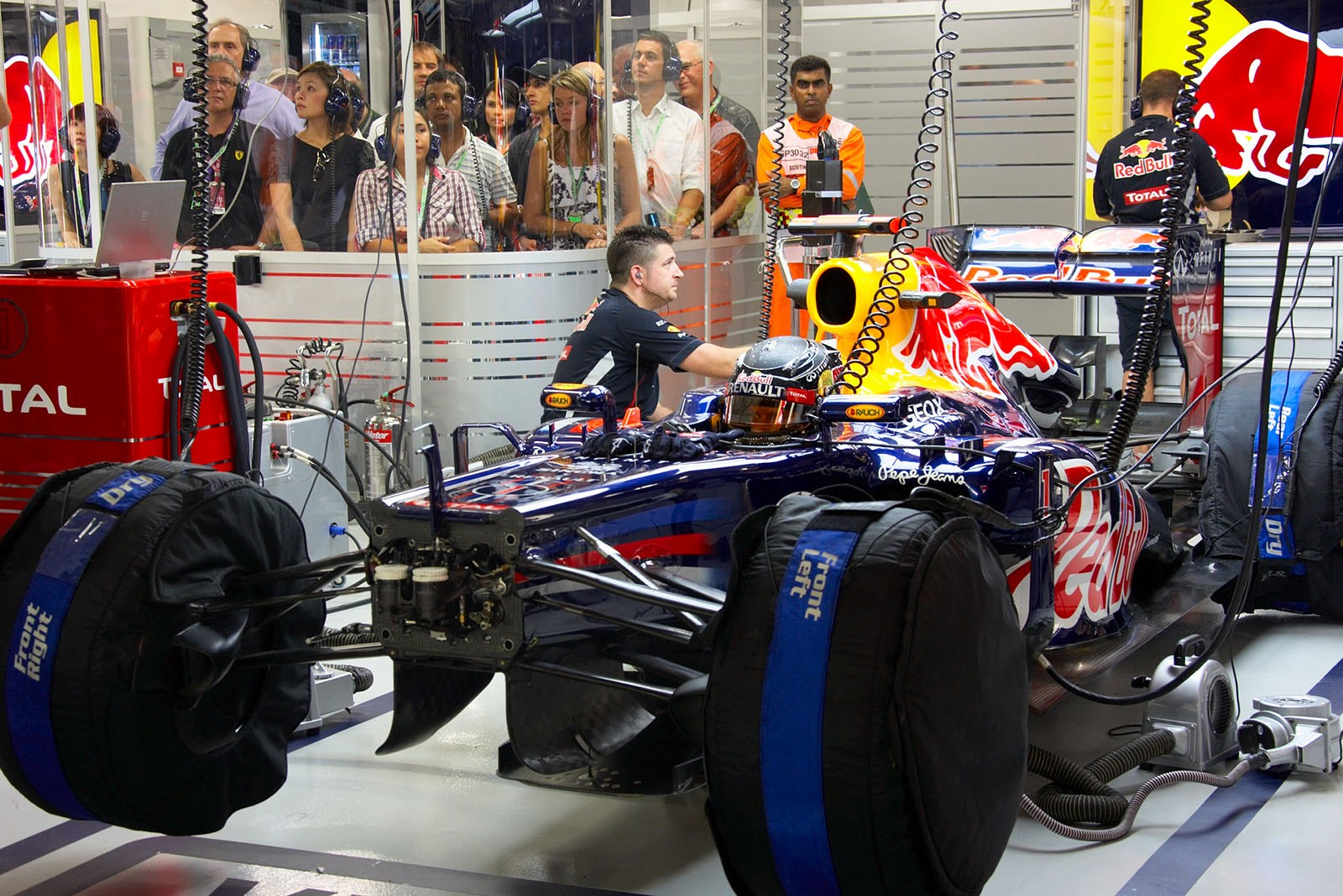 Sebastian Vettel, Red Bull Racing, sits in his race car whilst VIP fans watch from their reserved space in pits